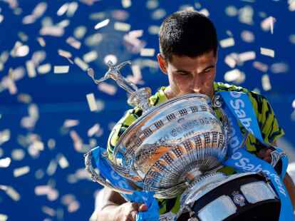Carlos Alcaraz h&auml;lt den Pokal nach seinem Sieg.