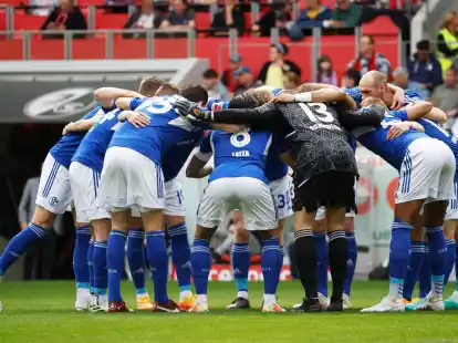 Die Spieler des FC Schalke 04 stehen vor Spielbeginn gemeinsam auf dem Platz im Kreis.
