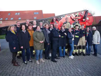 Dr. Katrin Greve (Mitte), Pr&auml;sidentin Lions-Club Jever &bdquo;Maria Wiemken&ldquo;, &uuml;bergibt ein Muster-T-Shirt, an Ortsbrandmeister-Stellvertreter Torsten Schoster.
