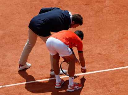 Novak Djokovic (r) diskutiert mit einem Offiziellen um einen Punktgewinn.