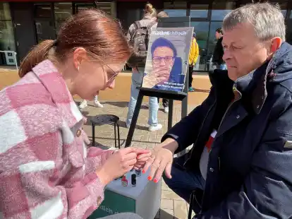 Rot lackierte M&auml;nnerhand: Ineke Saathoff versch&ouml;nert ihrem Kollegen Georg Wagner-Kyora die N&auml;gel.