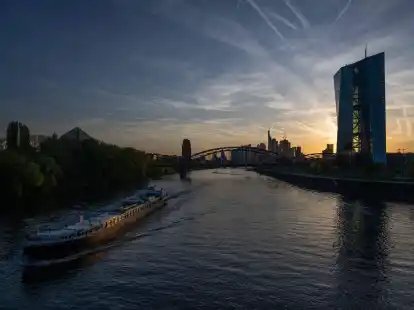 Ein Schiff f&auml;hrt bei Sonnenuntergang an der EZB in Frankfurt vorbei.