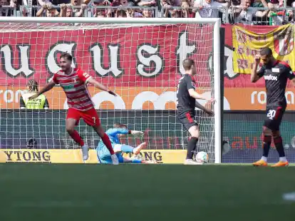 Augsburgs Dion Drena Beljo (l) jubelt nach seinem Tor zum 1:0, der Berliner Torwart Frederik R&ouml;nnow (M) schaut dem Ball im Netz nach.