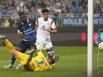 St. Paulis Elias Saad (r) trifft gegen Darmstadts Patric Pfeiffer (l) und Torwart Marcel Schuhen zum 0:2.