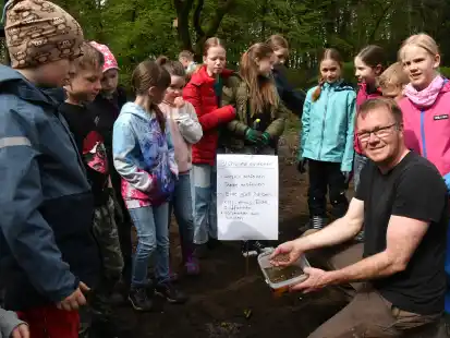 Im Schulgarten der Grundschule Dötlingen: Dirk Orth zeigte den Kindern, wie sie die Blühmischung am besten in die Erde bringen.