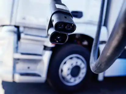 Ein Ladestecker h&auml;ngt im Mercedes-Benz Trucks KundenCenter vor einem Lastwagen. Der Konzern konnte seinen Gewinn im ersten Quartal nahezu verdreifachen.