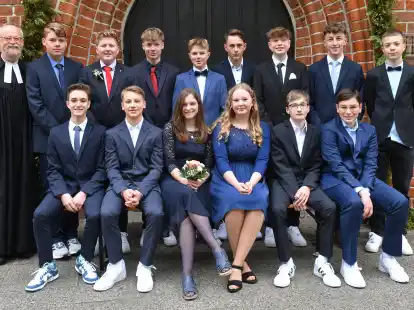 Sind von Pastor Reiner Backenk&ouml;hler (links) konfirmiert worden: Bent Speckmann (hintere Reihe von links), Niklas Stein, Felix Schumacher, Mika Reder, Raik Eilers, Leonard Gieschler, Kian Schmidt, Lasse Wesemann sowie (vordere Reihe von links) Levi Westermeyer, Jacob Speer, Tisha Renken, Aurelia Fritschka, Finn Lebherz und Mica Linnemann