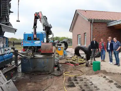Im k&uuml;nftigen Garten der &bdquo;Kita f&uuml;r Alle&ldquo; in B&ouml;sel, werden gerade 250 Meter tiefe Bohrungen f&uuml;r die W&auml;rmepumpen gesetzt. Bauleiter Thomas Theilmann (von rechts) erl&auml;utert Josef Runden von der Gemeindeverwaltung B&ouml;sel, der k&uuml;nftigen Kitaleiterin Stephanie M&ouml;dden und  Bernhard Hempen, Bereichsleiter Kinder und Jugend beim Caritas-Verein Altenoythe, das Bohrverfahren.