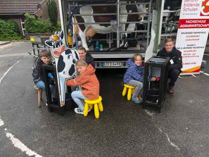 Lars Jansen (Zweiter von links) und Wilko Kuhlmann (ganz rechts) erkl&auml;ren Grundsch&uuml;lern der Grundschule Cleverns den Melkstand.