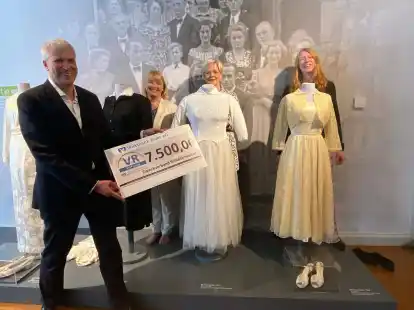 Einen symbolischen Scheck &uuml;ber 7500 Euro von der VR-Stiftung &uuml;berreichte (von links) Knut Kreye an Museumsleiterin Prof. Dr. Antje Sander. Volksbank-Pressesprecherin Susanne Leiting und Kuratorin Dr. Maren Siems hatten sich f&uuml;r das Pressefoto hinter historische Brautkleider gestellt.
