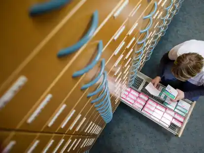 Eine Mitarbeiterin einer Apotheke sucht Medikamente aus einem Schubfach. Das passende Mittel zu finden und zu bekommen, wird jedoch immer schwieriger.