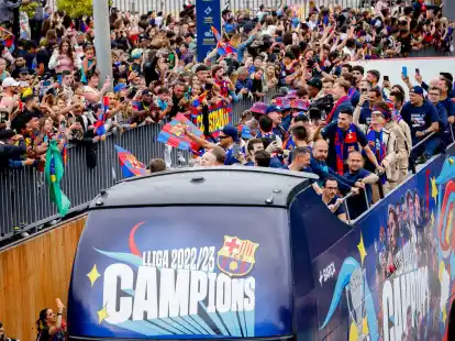 Spieler des FC Barcelona fahren mit einem offenen Bus durch die katalanische Metropole.