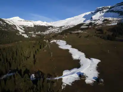 Blick auf die Talabfahrt aus Kunstschnee in Graub&uuml;nden. In vielen Wintersportgebieten ist es derzeit eher gr&uuml;n statt wei&szlig;.