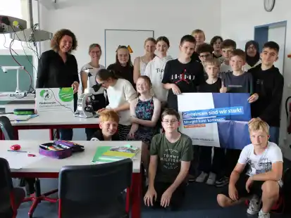 Bettina Sauter und Dr. Neele Schneider mit Sch&uuml;lerinnen und Sch&uuml;ler der Klasse 7b pr&auml;sentieren eines der beiden neuen Digitalmikroskope, die mit Geldern aus der Gewinnaussch&uuml;ttung der Volksbankstiftung angeschafft werden konnten.