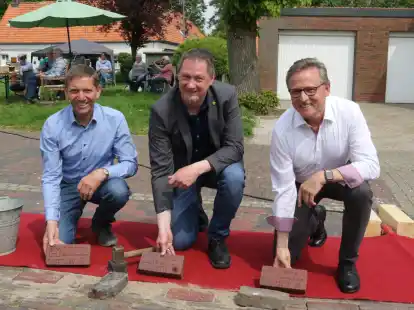 Ovelg&ouml;nnes B&uuml;rgermeister Sascha Stolorz (Mitte) sowie die ehemaligen Verwaltungschefs Dieter Kohlmann (links) und Christoph Hartz (rechts) setzten die gebrannten Klinkersteine ein.