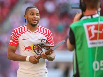 Leipzigs St&uuml;rmer Christopher Nkunku h&auml;lt die Torsj&auml;gerkanone in den H&auml;nden.