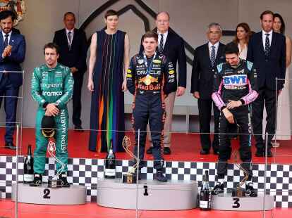 Monaco-Sieger Max Verstappen (M) steht zwischen dem Zweitplatzierten Fernando Alonso (l) und Esteban Ocon auf dem Siegerpodium.