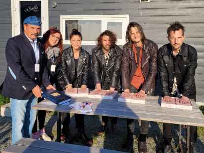 Gerd Thellmann (v. l.) und Gritje Peters nehmen die Handabdr&uuml;cke der Silbermond-Musiker.