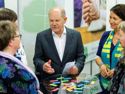 Kanzler Olaf Scholz unterh&auml;lt sich bei einem Rundgang auf dem Messegel&auml;nde.