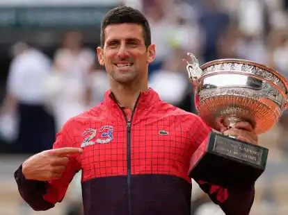 Novak Djokovic zeigt auf die 23 auf seiner Trainingsjacke und jubelt &uuml;ber seinen Sieg.