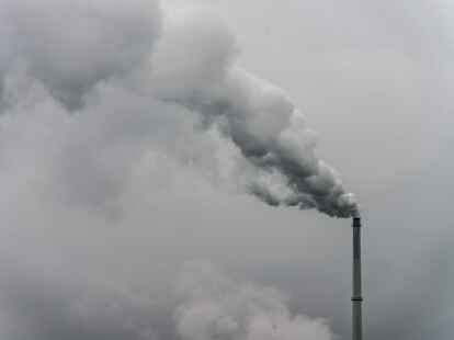 Qualm steigt aus dem Schornstein einer Fabrik im bayerischen Plattling.