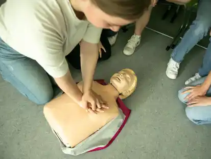 Mit K&ouml;rpereinsatz wird der Brustkorb der &Uuml;bungspuppe von den Sch&uuml;lerinnen und Sch&uuml;lern der Klasse 9d nach unten gedr&uuml;ckt. Bei der Herzdruckmassage soll circa 100 Mal pro Minute gedr&uuml;ckt werden.