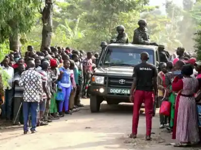 Ugandische Sicherheitskr&auml;fte fahren an einer Menschenmenge vorbei, die sich nach dem Angriff vor der Schule in Mpondwe versammelt hat (Videostandbild).