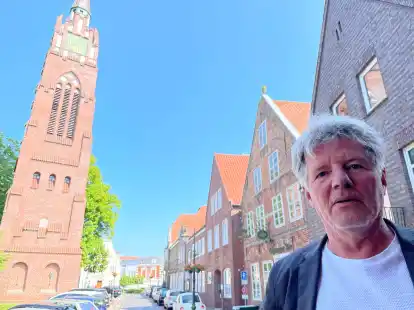 Pfarrer R&uuml;diger M&ouml;llenberg auf dem Treppenabsatz seines Pfarrhauses. Im Hintergrund die Stadtkirche und das Gemeindehaus am Kirchplatz.