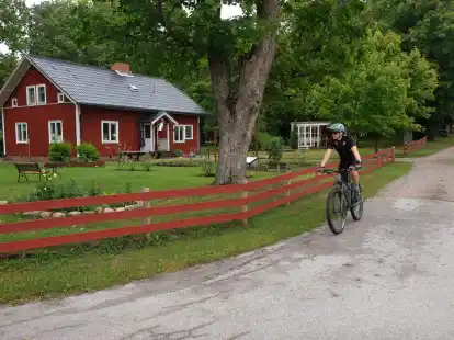 Immer wieder rollt man, wie hier im Weiler Asen, an typischen Schwedenh&auml;usern vorbei.