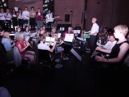 Frank Roloff (stehend) geht in den Ruhestand und leitete zum letzten Mal die Bl&auml;ser-AG des Mariengymnasiums beim Schulkonzert in der Stadtkirche in Jever.  Frauke Harland (rechts) &uuml;bernahm die Gesamtleitung des Konzerts.