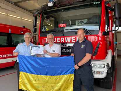 Peter Hoffbauer (links), Sandes B&uuml;rgermeister Stephan Eiklenborg und Rolf Steen (rechts) vor dem neuen Feuerwehrfahrzeug HLF. Das fr&uuml;here TLF wurde in die Ukraine gespendet.
