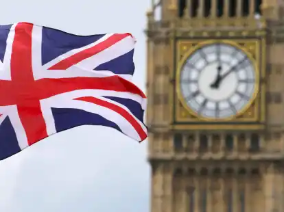 Eine Britische Fahne weht vor dem ber&uuml;hmten Uhrenturm Big Ben in London.
