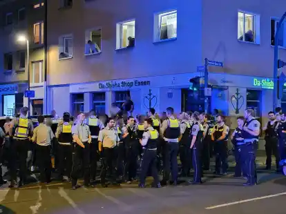 Polizisten bewachen mutma&szlig;liche Teilnehmer einer Massenschl&auml;gerei in der Essener Innenstadt.