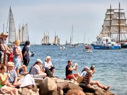 Menschen verfolgen an der F&ouml;rde die Windjammerparade.