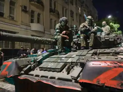 Angeh&ouml;rige des Milit&auml;runternehmens Wagner Group sitzen auf einem Panzer auf einer Stra&szlig;e in Rostow am Don, Russland, bevor sie einen Bereich im Hauptquartier des s&uuml;dlichen Milit&auml;rbezirks verlassen.