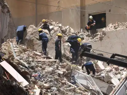 Mitglieder des &auml;gyptischen Zivilschutzes bei den &Uuml;berresten des eingest&uuml;rzten 13-st&ouml;ckigen Wohngeb&auml;udes in Alexandria.
