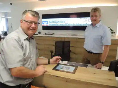 Die Raiffeisenbank Wiesedermeer hat mit ihrem Kundenraum und Penpads f&uuml;r die digitale Unterschrift bereits Ma&szlig;nahmen nach den Gesichtspunkten der Nachhaltigkeit ergriffen. Im Bild die Bankvorst&auml;nde Gero Hirsch (links) und Lars Dominik.