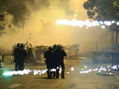 Beamte der Bereitschaftspolizei patrouillieren bei Unruhen auf einer Stra&szlig;e in Nanterre.