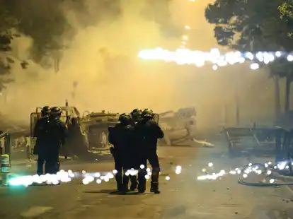 Beamte der Bereitschaftspolizei patrouillieren bei Unruhen auf einer Stra&szlig;e in Nanterre.