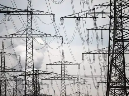 Strommasten auf einem Acker. Das Umweltbundesamt macht konkrete Vorschl&auml;ge, wie die Klimaziele bis 2030 doch noch erreicht werden k&ouml;nnten.