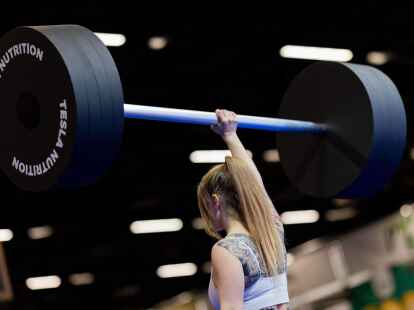Eine Besucherin hebt an einem Messestand auf der Fitnessmesse Fibo eine Hantel aus Styropor hoch. Die Fibo ist die nach eigenen Angaben weltgr&ouml;&szlig;te Messe f&uuml;r Fitness, Wellness und Gesundheit.