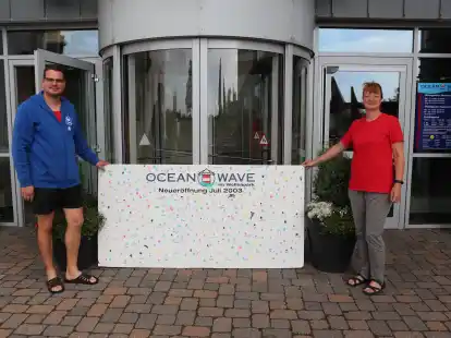 Vor 20 Jahren hinterlie&szlig;en Kinder zur Er&ouml;ffnung des Erlebnisbads Ocean Wave ihre Fingerabdr&uuml;cke. Nils Jenssen und Birgit Langner (v. l.) vom Ocean Wave-Team sind gespannt, ob sich noch jemand auf dem Schild wiedererkennt.