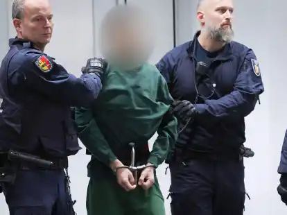 Der Angeklagte Ibrahim A. wird von Justizbeamten an seinen Platz im Gerichtssaal gebracht.