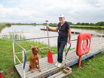 Gut gelaunt an seinem Arbeitsplatz am Ufer der Leda: Jens Riemann mit seinem Hund Tepe.