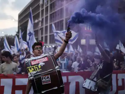 Israelische Demonstranten halten Fahnen und z&uuml;nden Fackeln w&auml;hrend eines Protestes gegen die Pl&auml;ne der Regierung von Premierminister Netanjahu, das Justizsystem zu reformieren.