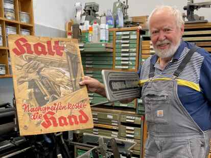 Sorgfalt geht vor Schnelligkeit: Michael Linke zeigt ein altes Warnschild aus der Druckerei.