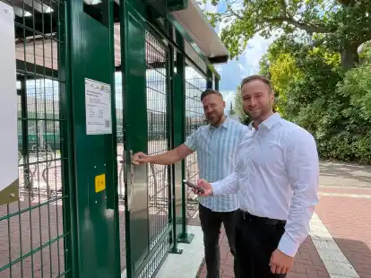 <p>Tobias Hartmann (links) und Tim Turowski stellten die neue Nutzung der Fahrradabstellanlage per App vor. An der Anlage ist genau erkl&auml;rt, wie das neue System funktioniert.</p>