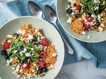 Wie ein bunter Strau&szlig;: Die roten Linsen bringen Farbe in den Salat mit Feta und Rucola. Himbeeren und Blaubeeren sorgen f&uuml;r einen fruchtigen Touch, Waln&uuml;sse und Cashewn&uuml;sse lassen es knacken.