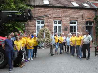 Das Werk ist getan: Helferinnen und Helfer betrachten die neue Erntekrone von St.-Magnus.