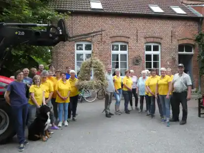 Das Werk ist getan: Helferinnen und Helfer betrachten die neue Erntekrone von St.-Magnus.